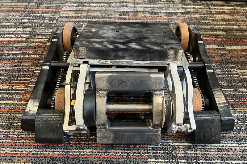 Boulderbot from the front, showing the weapon uprights, chain drive, and orange wheels.
